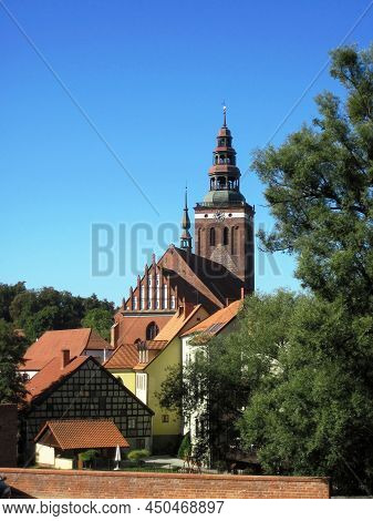 Beautiful View Of The Medieval Brick Clock Tower, Houses With Tiled Roofs In The Old Polish Town Of 