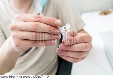 Hands Holding Covid-19 Rapid Antigen Test Kit Tube And Cotton Swab. Rapid Diagnostic Self-testing At