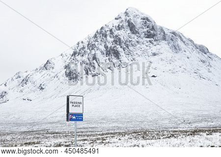 Buachaille Etive Mor Mountain And Empty Road Covered In Snow During Winter