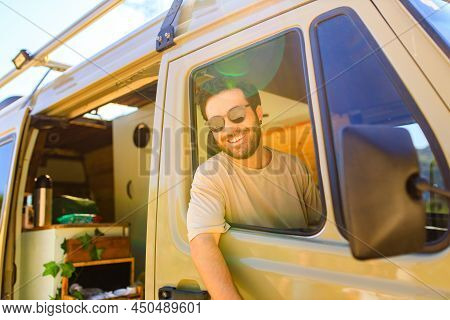 Man In Charming Trailer House Makes Coffee Outdoors In Mountains In Summer Sunny Day