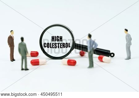 Medical Concept. On A White Surface Are Pills, Figurines Of People And A Magnifying Glass With The I