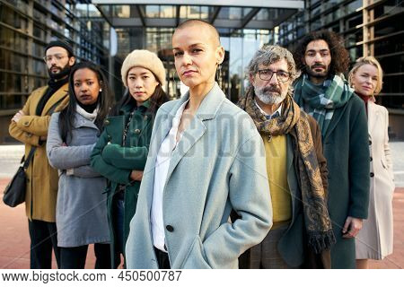 A Group Of Serious Business People From A Company Led By An Empowered Shaved Air Woman. Looking At C