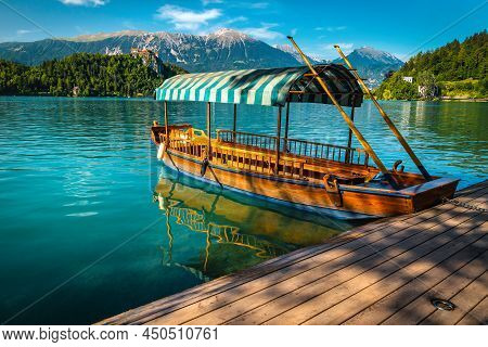 Traditional Touristic Wooden Rowing Pletna Boat Anchored At The Pier. Wooden Pletna Boat On The Famo