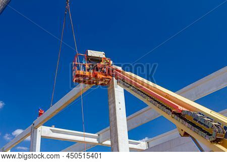 Mobile Crane Is Operating And Worker Is Assembly Concrete Joist In High Place. Height Worker Is Plac