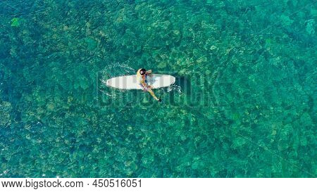 Aerial Top View Of Sporty Young Man While She Riding On Sup Board In Turquoise Water. Inflatable Sup