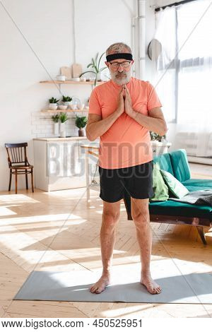 Elderly Aged Male Doing Meditation. Old Person Man Pensioner Healthy Training Healthcare At Home