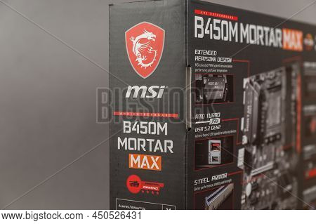 Msi B450 Mortal Max Motherboard Against A Gray Background. Black Box With The New Computer Hardware.