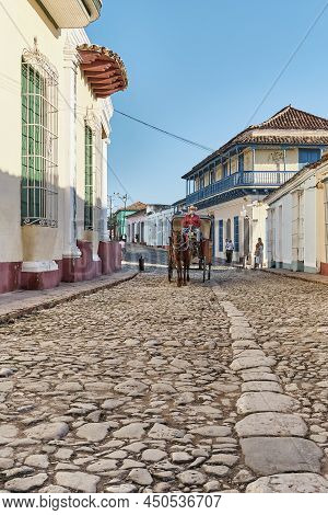 Trinidad, Cuba - February 12, 2022: Cobblestone Street In Colonial Old Town. Cabman On Horse-drawn C