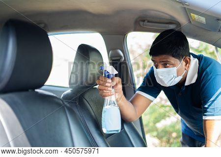 Cab Or Car Taxi Driver With Medical Face Mask Sanitizing Passenger Seat - Concept Of Coronavirus Cov
