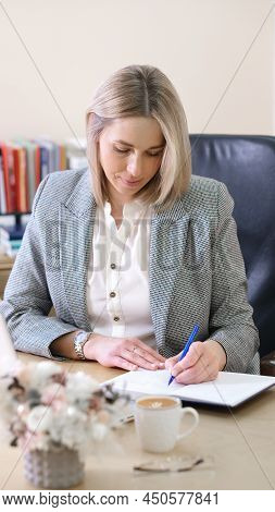Left Handed Woman Boss Writing In A Notebook Planning Working Day. Employer Woman Wearing Formal Cho