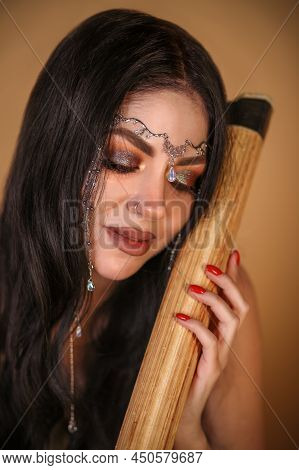 Closeup Portrait Of A Pretty Young Woman Embracing A Wooden Stick