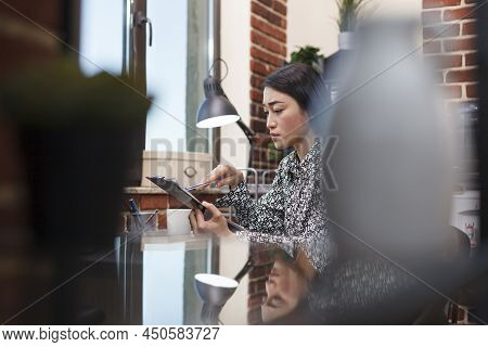Asian Businesswoman Checking Business Project Management Plan While In Marketing Company Office. You