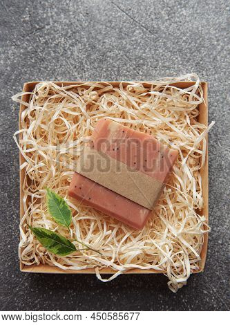 Assorted Natural Handmade Soap Bars And Green Leaves On A Straw Background