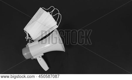 Megaphone And Face Mask On Black Background. Top Eye View And Nopeople.studio Shot. Black And White 