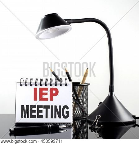 Iep Meeting Text On Notebook With Pen And Table Lamp On Black Background