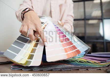 Closeup Hand Of Woman Decorator Interior Designer Is Choosing Catalogue Colors Ral For Project