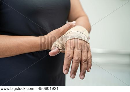 Asian Middle-aged Lady Woman Use Elastic Bandage To Treating De Quervain Syndrome At Hand And Finger