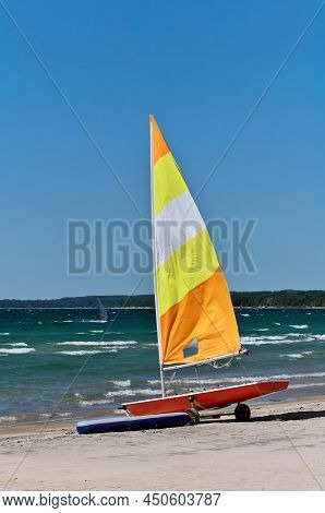 Colorful Sailboat On Trailer And Rubber Dinghy On Beach Ready For Action