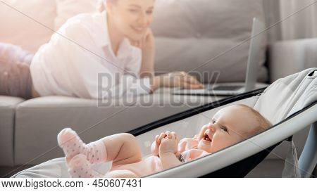 Closeup Baby In Automatic Carrycot, Businesswoman Working At Home Office Using Laptop Computer With 