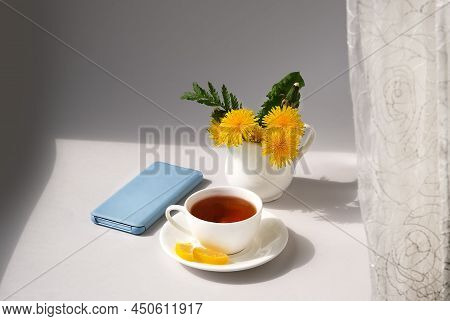 Cup Of Tea, Dandelion Flowers And Phone. Spring Morning.