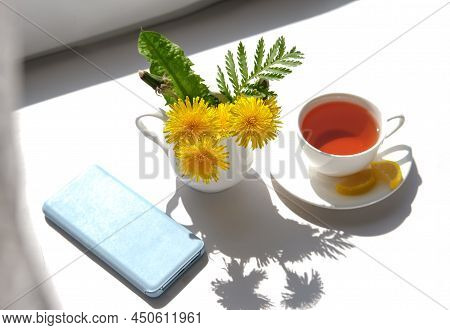 Cup Of Tea, Dandelion Flowers And Phone. Spring Morning.