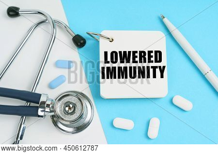 Medical Concept. On A White And Blue Surface Are Pills, A Stethoscope, A Pen And A Notepad With The 