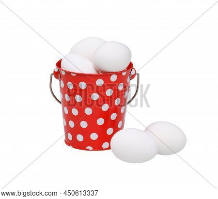 A Cute Red Bucket With White Dots Full Of Eggs. Two Eggs Next To Him. Isolated On White