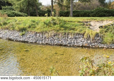 Strengthening The Banks Of The River, Mesh And Stones. Landscape River Bank And Large Stones With Me