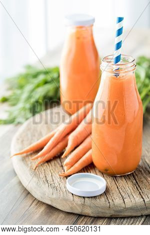 Close Up Of Two Bottles Of Freshly Made Carrot Juice Ready For Drinking.