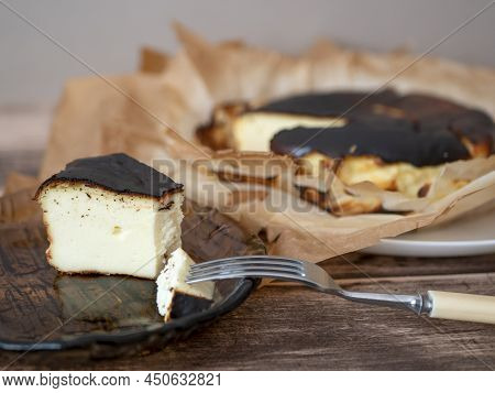 Basque Burnt Cheesecake Slice With A Burnished Exterior And A Creamy Custardy Interior On A Brown Gl