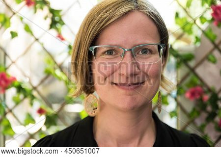 Portrait Of A Thirty Year Old White Caucasian Lady With Glass, Golden Earrings And A Black Dress, Br