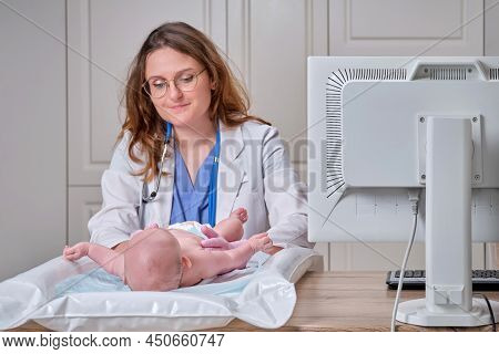 The Doctor Does Gymnastics And Massage To A Newborn Baby. Nurse In Uniform Doing Warm-up Exercises T