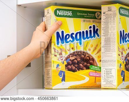 Tambov, Russian Federation - February 19, 2022 Woman Hand Taking Nestle Chocolate Nesquik Cereal Box
