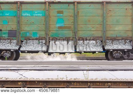 Old And Long Unpainted Railway Wagon For Bulk Cargo Finishes Unloading Rubble, Selective Focus
