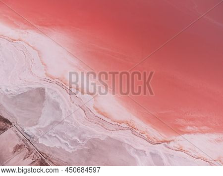 Flying Over A Pink Salt Lake. Salt Production Facilities Saline Evaporation Pond Fields In The Salty