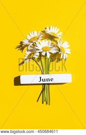 Calendar Summer Month June And Chamomile Flowers On Yellow Background. Top View Flat Lay. Minimal Co