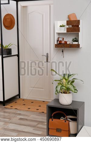 Hallway Interior With Stylish Accessories And Wooden Hanger For Keys On White Wall