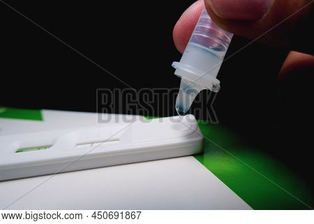 Own Hand Placing The Droplet Secretions Sample Into The Sars Cov-2 Rapid Antigen Test Kit (atk) With