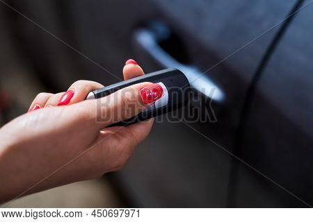 The Car Owner Holds In His Hand A Remote Control Device For Keyless Entry. Close-up, Selective Focus