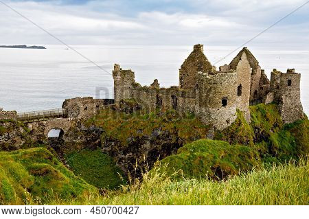 Ruins Of Dunluce Castle, Antrim, Northern Ireland During Sunny Day With Semi Cloudy Sky. Irish Ancie