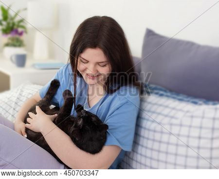Happy Teen Girl With Black Cat In White Bedroom