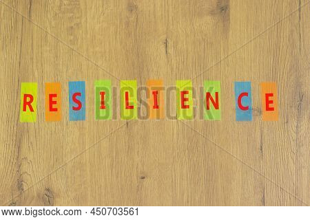 Resilience Success Symbol. The Concept Word Resilience On Colored Papers On A Beautiful Wooden Backg