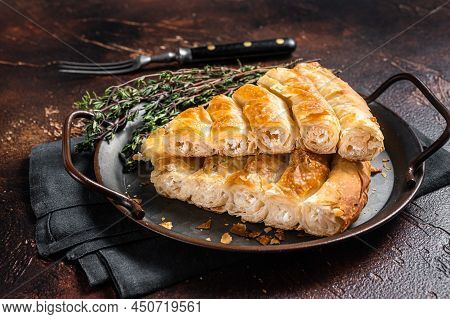 Slices Of Baked Round Borek Cheese Pie In Kitchen Tray With Herbs. Dark Background. Top View. Copy S