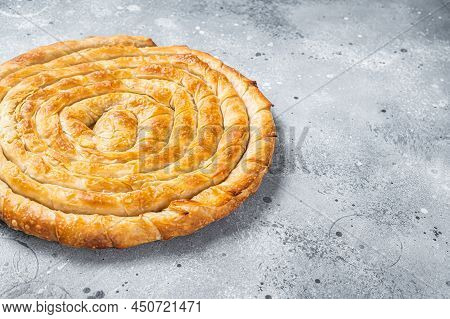 Baked Homemade Traditional Greek Cheese Pie On Kitchen Table. Gray Background. Top View. Copy Space