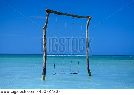 Ocean Swing, Perfect Lagoon. Copy Space. Ocean Swing With Blue Sky Background. Beach Seesaw Without 