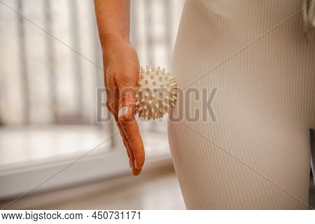 Athletic Slim Caucasian Woman Doing Thigh Self-massage With A Massage Ball Indoors. Self-isolating M