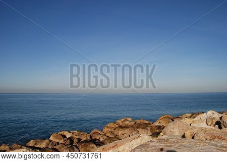 Sea View From A Stone Breakwater. Mediterranean Sea, Sunny Day. Breakwater Stones Close Up. Blue Sur
