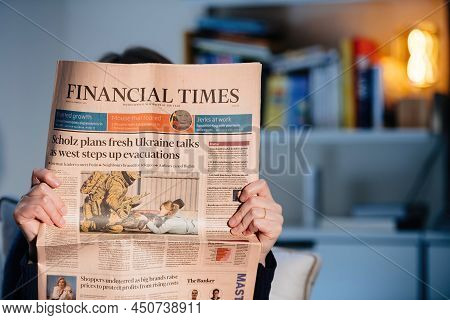 Paris, France - Feb 23, 2022: Woman Reading Financial Times Newspaper With The Cover Headline Scholz