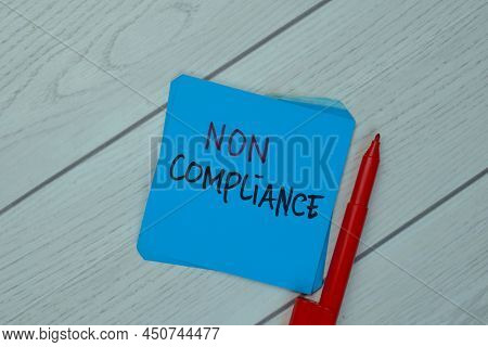 Non Compliance Write On Sticky Notes Isolated On Wooden Table.