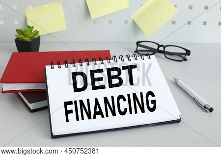 Debt Financing Work Table And Stickers On The Dost. Notepad Text On Page